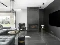 Nowoczesny salon z kominkiem inspiracje: szara sofa, czarny fotel, okrągły stolik kawowy i duży telewizor na ciemnej ścianie.