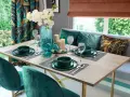 Elegancka codzienna dekoracja stołu w salonie: zielone zastawy, szklane ptaszki i świece tworzą przytulną atmosferę.