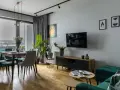 Nowoczesny szary salon inspiracje: jadalnia z welurowymi krzesłami, salon z TV i zieloną kanapą.