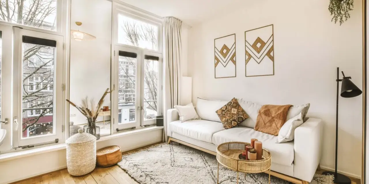 Jasny salon w stylu skandynawskim z wygodną sofą, dywanem i naturalnymi dodatkami.