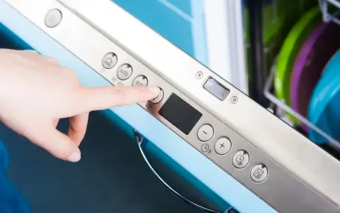 Dłoń naciska przycisk "eco" na panelu zmywarki Electrolux, przygotowując ją do ekologicznego cyklu czyszczenia.