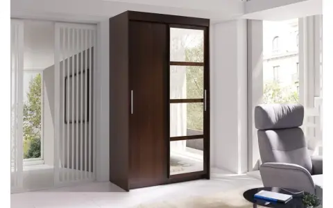 Szafa w kolorze wenge, z lustrzanymi frontami, obok szarego fotela i stolika.