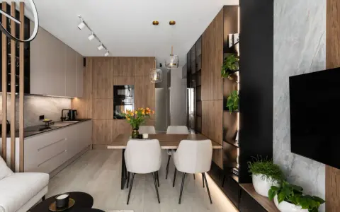 Nowoczesny salon z kuchnią i jadalnią 40m2. Drewniane akcenty, jasne meble i rośliny tworzą przytulną atmosferę.