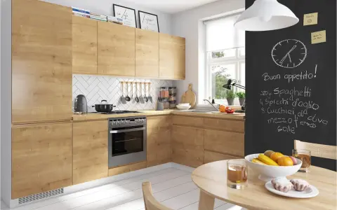 Nowoczesna kuchnia z drewnianymi frontami. Na czarnej ścianie przepis na spaghetti. Zastanawiasz się, czym czyścić blaty kuchenne?