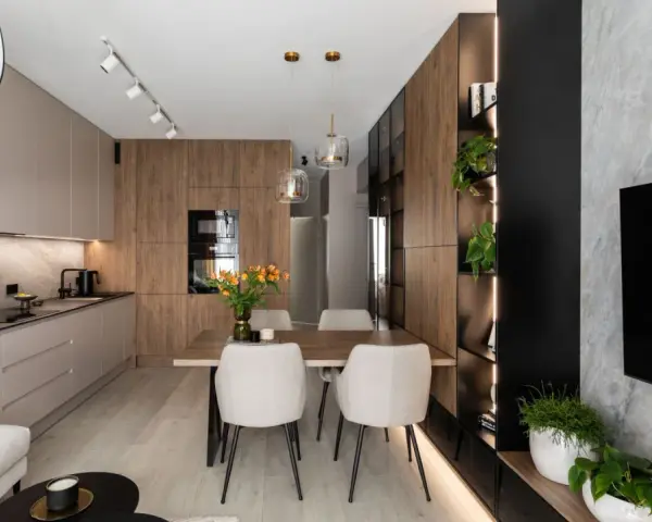 Nowoczesny salon z kuchnią i jadalnią 40m2. Drewniane akcenty, jasne meble i rośliny tworzą przytulną atmosferę.