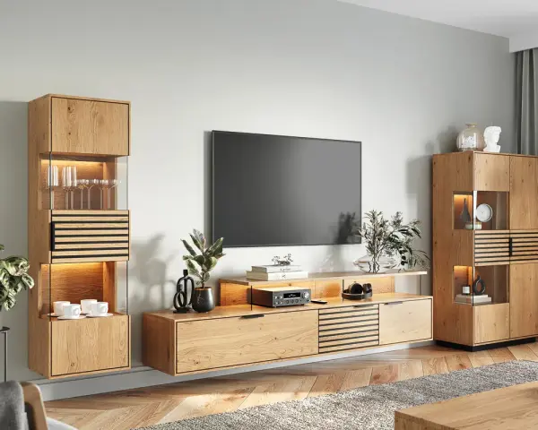 Nowoczesny salon z drewnianą komodą, na której stoi telewizor. Obok wisząca szafka z podświetlanymi półkami.