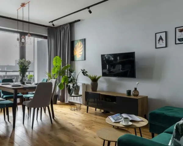 Nowoczesny szary salon inspiracje: jadalnia z welurowymi krzesłami, salon z TV i zieloną kanapą.