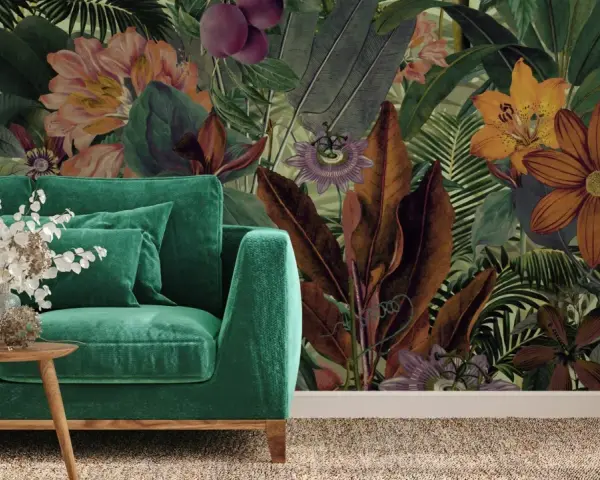 Aksamitna sofa w odcieniach zieleni, obok niej drewniane stoliki z bukietem. W tle bujna, tropikalna tapeta z kwiatami i liśćmi.