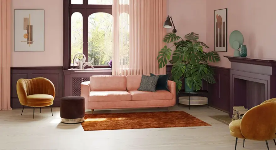 Przytulny salon z kanapą w kolorze pudrowy róż, aksamitnym fotelem i dużą rośliną.