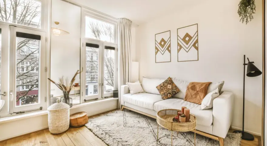 Jasny salon w stylu skandynawskim z wygodną sofą, dywanem i naturalnymi dodatkami.