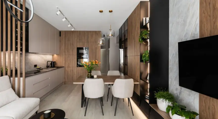 Nowoczesny salon z kuchnią i jadalnią 40m2. Drewniane akcenty, jasne meble i rośliny tworzą przytulną atmosferę.