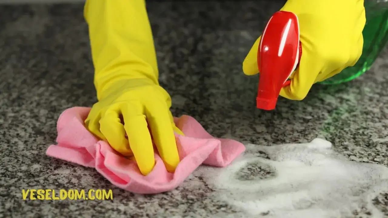 Rękawiczki w ż&oacute;łtym kolorze czyszczą blat z pianą. Dowiedz się, jak usunąć super glue z blatu.